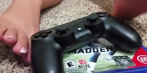 Girl with french pedicure playing with playstation controller with her sexy feet