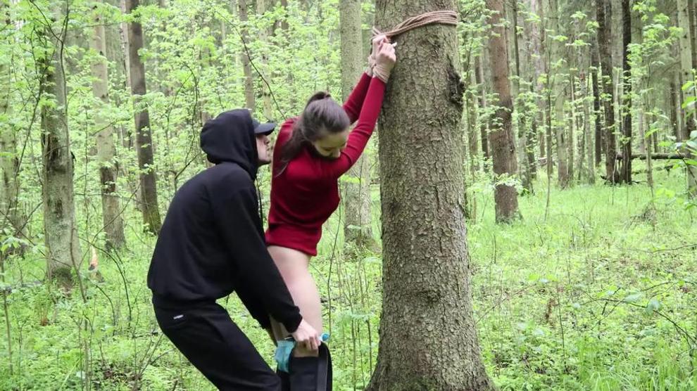 Whipping a Belt of a Sub Girl Tied to a Tree in a Dense Forest pic