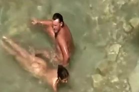 Nudist couple in water at beach