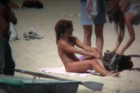 Horny naked brunette woman teasing her mates on the beach
