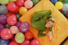 Contortionist blonde plays with balloons