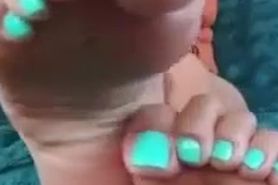 Curly haired asian girl exposing soles and turquoise toes