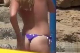 Thong babe on the beach has perky boobs