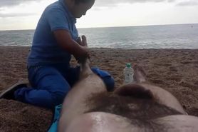 Hairy guy gets a leg massage on the beach