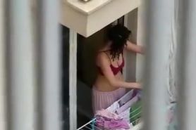 Lovely neighbor girl is hanging clothes