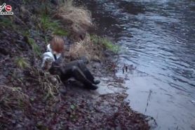 Russian Blonde in muddy chest Waders enjoying riverside Mud