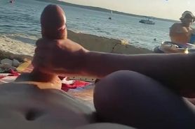 On a nude beach the wife stokes my dick while a voyuer watches