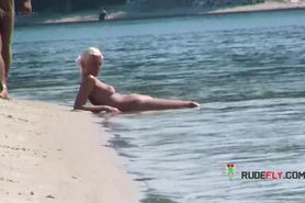 Playful blond nudist teen caught on camera naked at the beach