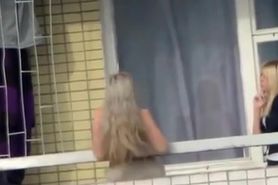 Voyeur films topless chick in the balcony