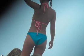 Asian teen girl bends over on beach