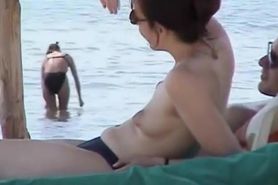 Topless babes getting caught on tape while acting naughty on the public beach