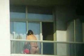 Topless brunette hottie filmed from a window