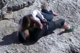 Girl masturbates her guy in the rocks