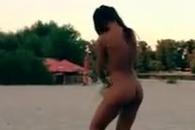 Nude Innuska playing frisbee on the beach