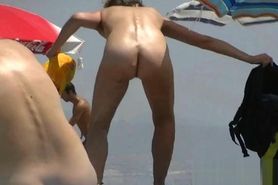 Nudist video at the beach has shy girl playing in the water