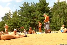 Wives and their husbands sunbathing at the nudist beach
