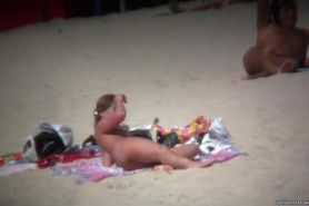 Brunette cutie with a perky butt filmed on a nudist beach