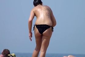 Classless chick with big boobs and tattoo's on a beach