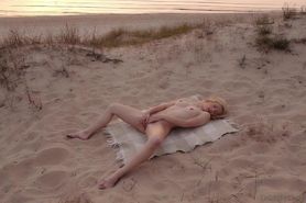 Blonde plays with pussy on beach at sunset