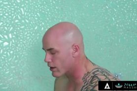 Horny ginger masseuse working on a tall bald inked man