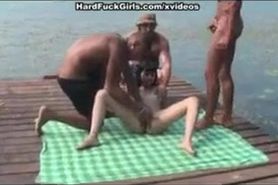 horny slutty nympho girl gives a trio of horny guys a blowjob on the docks while friend films her on camera