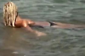 Guy splashes a topless girl with water