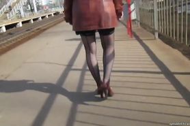 Girl in seamed stockings going upstairs on a train station
