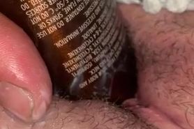 Stuffing a bottle in her pussy