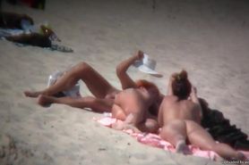 Nude sun tanning girls expose themselves to a beach spy cam