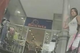 Woman in white skirt gets filmed by a nasty voyeur in the shop