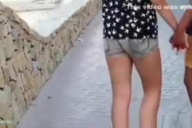 Girl in tight shorts curls ass.